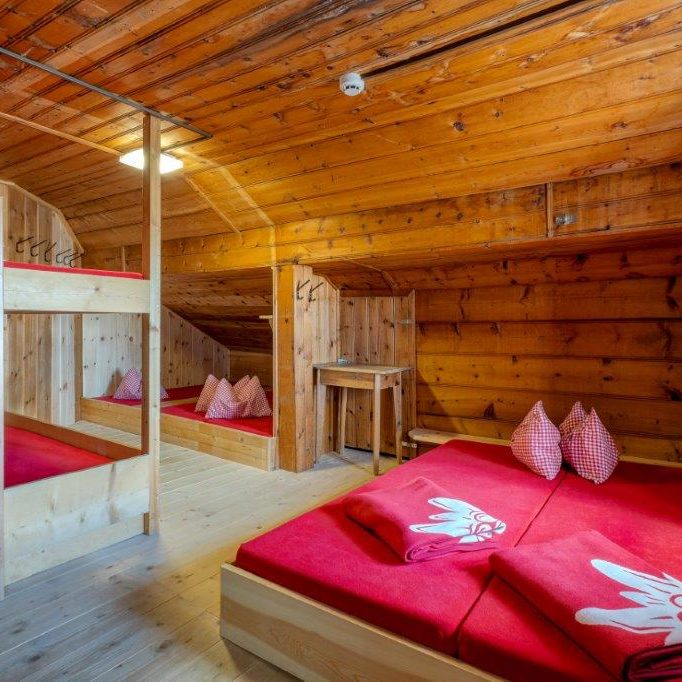 liebevoll hergerichtetes Matratzenlager mit viel Platz und roten DAV-Decken